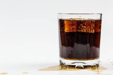 Beyaz arka planda buzlu bardakta siyah soda.