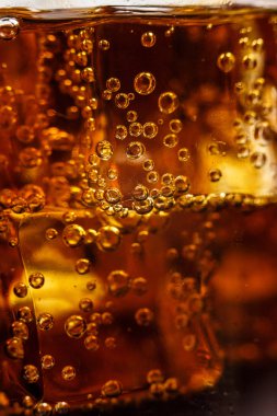 Beyaz arka planda buzlu bardakta siyah soda.