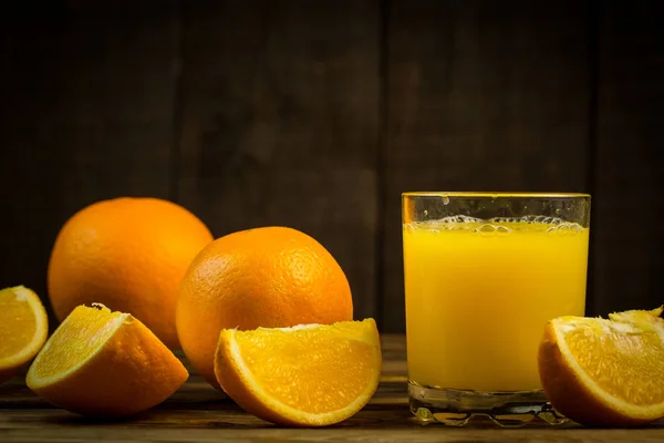 Glas Sinaasappelsap Schijfjes Sinaasappel Een Houten Tafel — Stockfoto