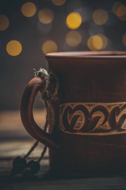 Kahverengi kil kahve fincanları ve ahşap bir masada sıcak renklerde lezzetli çikolatalı kurabiyeler.