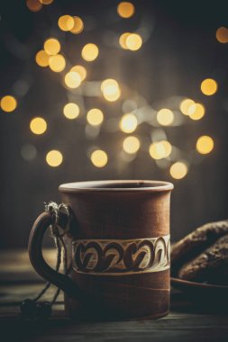 Kahverengi kil kahve fincanları ve ahşap bir masada sıcak renklerde lezzetli çikolatalı kurabiyeler.