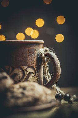 Kahverengi kil kahve fincanları ve ahşap bir masada sıcak renklerde lezzetli çikolatalı kurabiyeler.