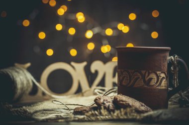 Kahverengi kil kahve fincanları ve ahşap bir masada sıcak renklerde lezzetli çikolatalı kurabiyeler.