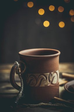 Kahverengi kil kahve fincanları ve ahşap bir masada sıcak renklerde lezzetli çikolatalı kurabiyeler.