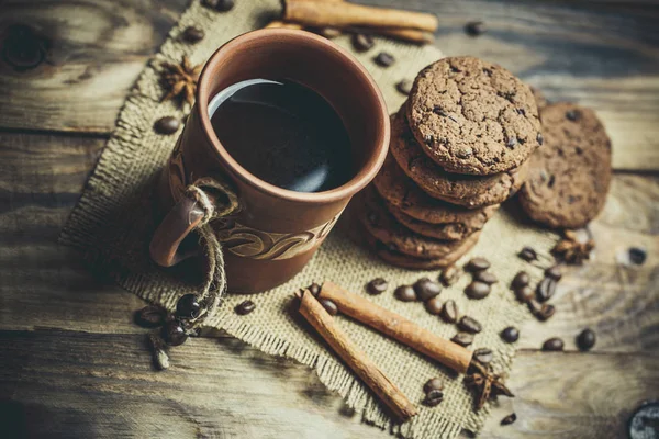红土咖啡杯和美味的巧克力曲奇饼放在一个色彩艳丽的木制桌子上 — 图库照片