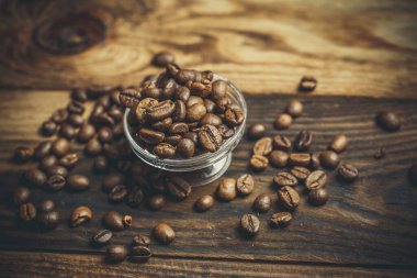 Bir sürü güzel kokulu kahve çekirdeği tahta bir masanın üzerinde duruyor.