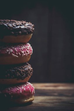 Tahta bir kahvaltı masasında çikolata ve pembe taze çörekler.