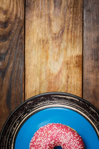 Leckere Rosa Donut Auf Einem Teller Auf Holzgrund — Stockfoto