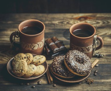 Çikolatalı lezzetli çörekler ve sıcak renkli bir fincan kahve..