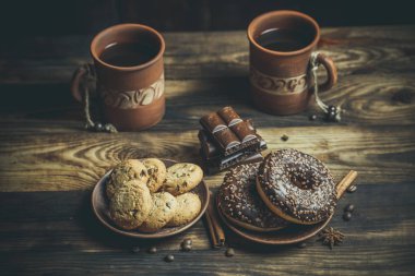 Çikolatalı lezzetli çörekler ve sıcak renkli bir fincan kahve..
