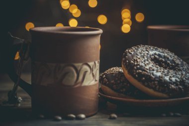 Çikolatalı lezzetli çörekler ve sıcak renkli bir fincan kahve..