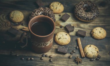 Çikolatalı lezzetli çörekler ve sıcak renkli bir fincan kahve..