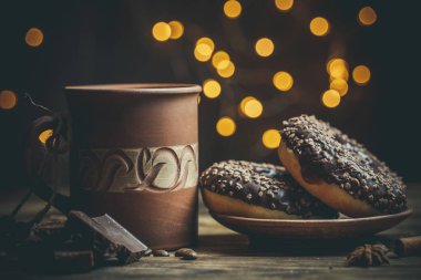 Çikolatalı lezzetli çörekler ve sıcak renkli bir fincan kahve..