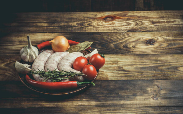 Много различных специй, овощей и ингредиентов, и свежие сырые сосиски барбекю для семьи
.