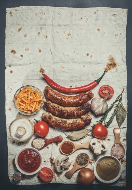 Kızarmış sosis, sebze, acı biber ve çeşitli baharatlar ve pide ekmeği.