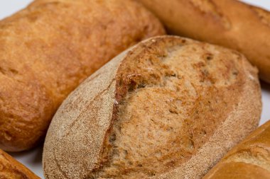 Beyaz zemin üzerinde buğday ve un bulunan lezzetli siyah beyaz ekmek.