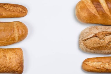 Beyaz zemin üzerinde buğday ve un bulunan lezzetli siyah beyaz ekmek.