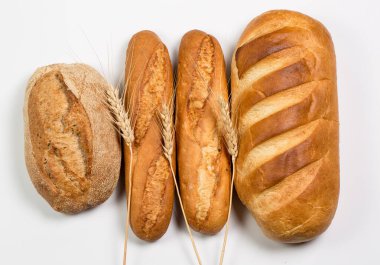 Beyaz zemin üzerinde buğday ve un bulunan lezzetli siyah beyaz ekmek.