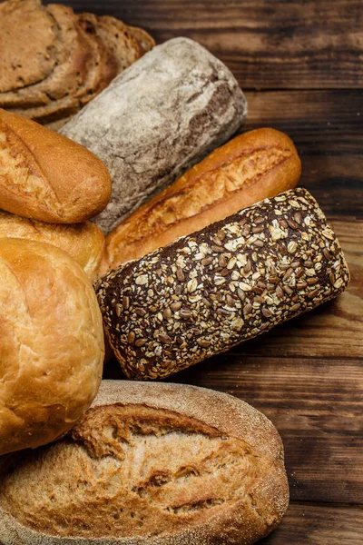 木製のテーブルの上に小麦や小麦粉とパンやロールの異なる愛 — ストック写真