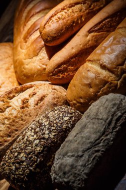 Tahta bir masada farklı somun ekmeği, buğday, un ve glüten.