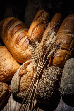 Tahta bir masada farklı somun ekmeği, buğday, un ve glüten.