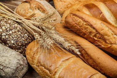 Tahta bir masada farklı somun ekmeği, buğday, un ve glüten.