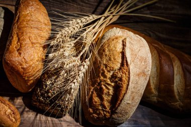 Tahta bir masada farklı somun ekmeği, buğday, un ve glüten.