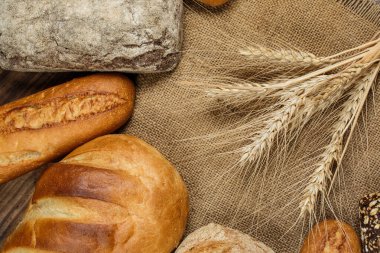 Tahta bir masada farklı somun ekmeği, buğday, un ve glüten.