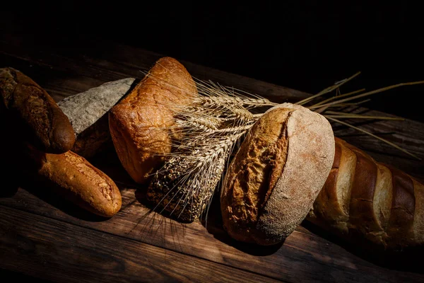 Různé Bochníky Chutného Chleba Pšenicí Moukou Lepkem Dřevěném Stole — Stock fotografie