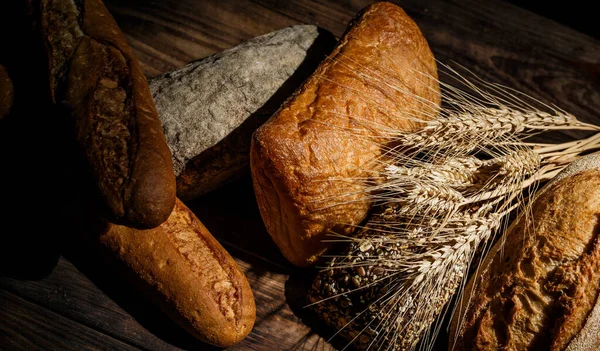 Různé Bochníky Chutného Chleba Pšenicí Moukou Lepkem Dřevěném Stole — Stock fotografie