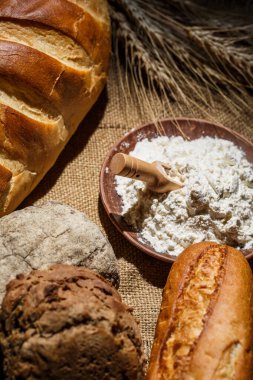 Tahta bir masada taze somun ekmek, buğday ve glüten.