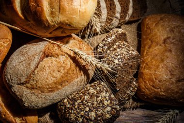 Tahta bir masada taze somun ekmek, buğday ve glüten.