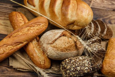 Tahta bir masada taze somun ekmek, buğday ve glüten.
