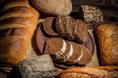 Tahta bir masada taze somun ekmek, buğday ve glüten.