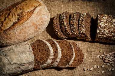 Tahta bir masada taze somun ekmek, buğday ve glüten.