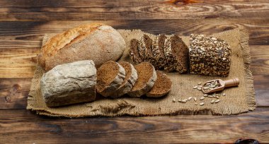 Tahta bir masada taze somun ekmek, buğday ve glüten.