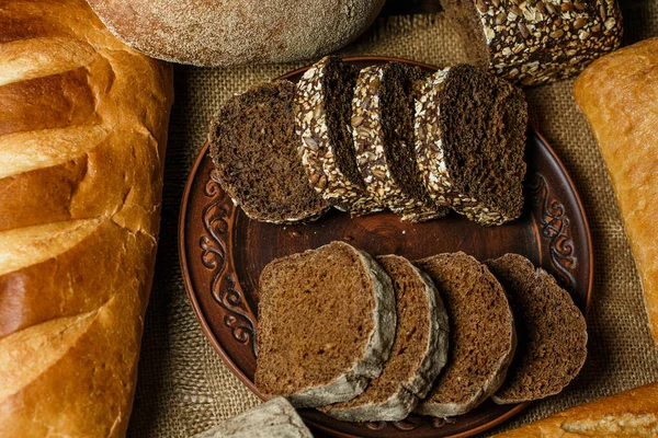 Tahta bir masada taze somun ekmek, buğday ve glüten.