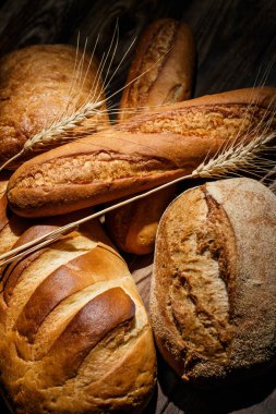 Farklı somun ekmeği un ve glütensiz buğdayla ahşap bir masada pişirilir.