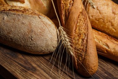 Farklı somun ekmeği un ve glütensiz buğdayla ahşap bir masada pişirilir.
