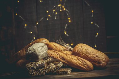 Farklı somun ekmeği un ve glütensiz buğdayla ahşap bir masada pişirilir.