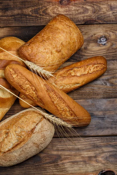 Różne Bochenki Chleba Gotowane Mąką Bezglutenową Pszenicą Drewnianym Stole — Zdjęcie stockowe