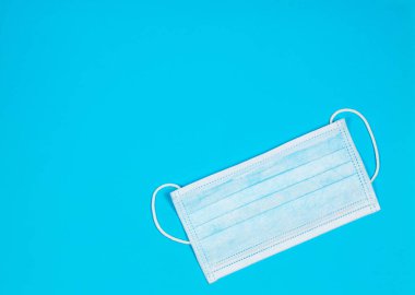 Mavi arka plandaki virüslere karşı korunmak için tıbbi maske