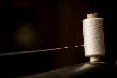 Dikiş makinesinin üzerinde duran beyaz iplik makarası