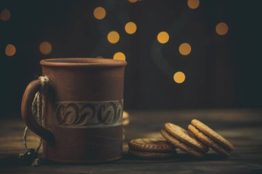 Yuvarlak tatlı kurabiyeler ve bir fincan çay eski usul ahşap bir masada.