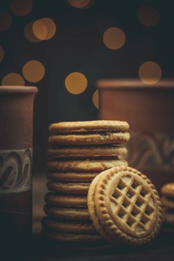 Yuvarlak tatlı kurabiyeler ve bir fincan çay eski usul ahşap bir masada.