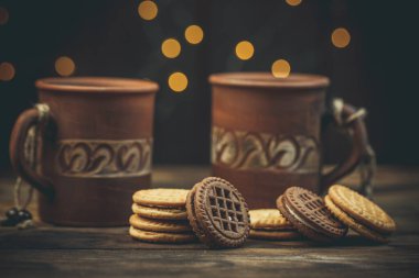 Yuvarlak tatlı kurabiyeler ve bir fincan çay eski usul ahşap bir masada.
