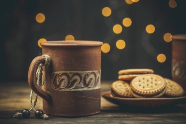 Yuvarlak tatlı kurabiyeler ve bir fincan çay eski usul ahşap bir masada.