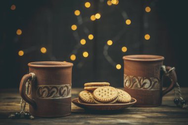 Yuvarlak tatlı kurabiyeler ve bir fincan çay eski usul ahşap bir masada.