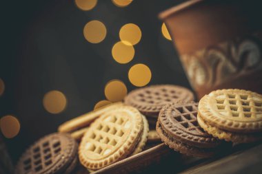 Yuvarlak tatlı kurabiyeler ve bir fincan çay eski usul ahşap bir masada.