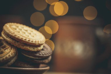 Yuvarlak tatlı kurabiyeler ve bir fincan çay eski usul ahşap bir masada.